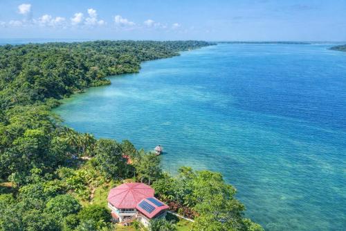 an island in the middle of the ocean with a red umbrella at Akwaba Lodge Island Boutique Hotel in The Gap