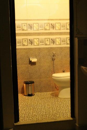 a bathroom with a toilet and a trash can at Ebenezer Plaza in Nedumbassery