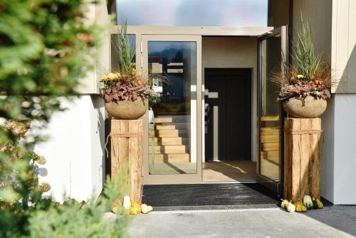 an entrance to a house with two potted plants on posts at Landgasthof Kreuz - Der Zwischenstopp mit Herz auf dem Weg in den Süden in Kappel bei Olten
