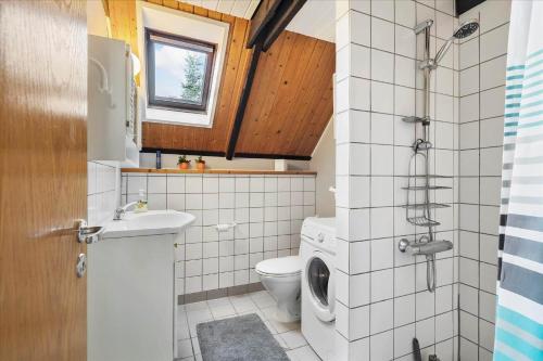 a bathroom with a toilet and a washing machine at 303-Hvide-Sande-Fyrmarken-36 in Hvide Sande