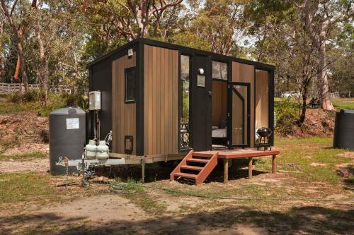 a tiny house with a picnic table in a field at Maroota Greens SKY by Tiny Away in Maroota