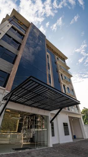 a tall building with a large glass facade at Hotel Harvest Retalhuleu in Santa Cruz Muluá