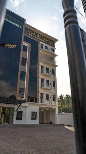 a building with a sign on the front of it at Hotel Harvest Retalhuleu in Santa Cruz Muluá