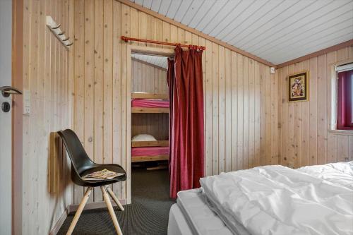 a bedroom with a bed and a chair in it at 467-Hvide-Sande-Tingodden-212 in Hvide Sande