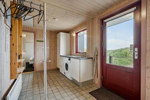 a bathroom with a washing machine and a red door at 467-Hvide-Sande-Tingodden-212 in Hvide Sande