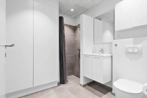 a white bathroom with a toilet and a shower at 774-Hvide-Sande-Norregade-2-nr-7 in Hvide Sande