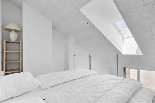 a white bedroom with a bed and a skylight at 774-Hvide-Sande-Norregade-2-nr-7 in Hvide Sande
