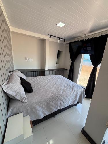 a bedroom with a bed and a television in it at Cantinho Sol e Sal in Guarapari
