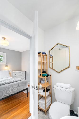 a bathroom with a bed and a toilet and a mirror at The Montlake Spite House in Seattle