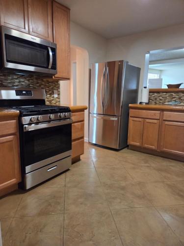 a kitchen with a stove and a stainless steel refrigerator at Quiet Desert Oasis off Swan Rd in Tucson
