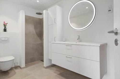 a white bathroom with a sink and a mirror at 777-Hvide-Sande-Norregade-2-nr-2 in Hvide Sande