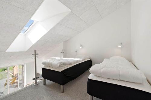 two beds in a white room with a window at 777-Hvide-Sande-Norregade-2-nr-2 in Hvide Sande