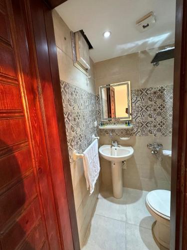 a bathroom with a sink and a toilet and a mirror at sun 3 pyramids view hotel in Cairo