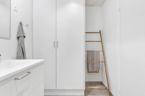 a white bathroom with a ladder next to a sink at 781-Hvide-Sande-Norregade-2-nr-9 in Hvide Sande