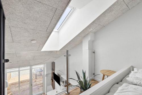 a loft conversion with a bed and a window at 781-Hvide-Sande-Norregade-2-nr-9 in Hvide Sande