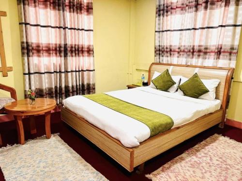 a bedroom with a bed and a table and curtains at D Eco Resort in Dhulikhel