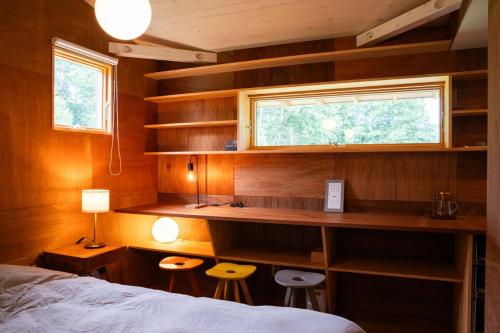 a bedroom with a bed and a desk and a window at White Bird in Hokuto