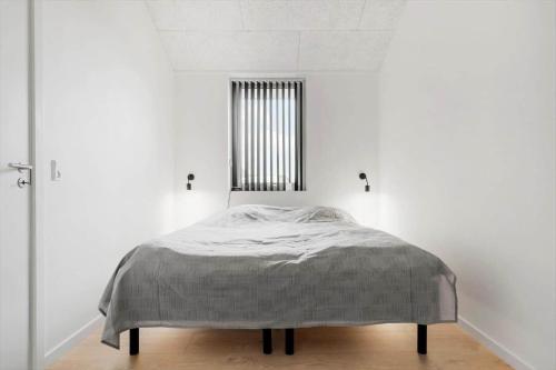 a bed in a white room with a window at 771-Hvide-Sande-Norregade-2-nr-28 in Hvide Sande