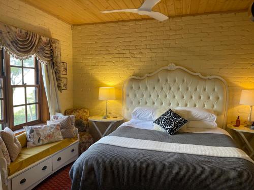 a bedroom with a large bed with a white headboard at Pear Tree Hollow in Bald Hills
