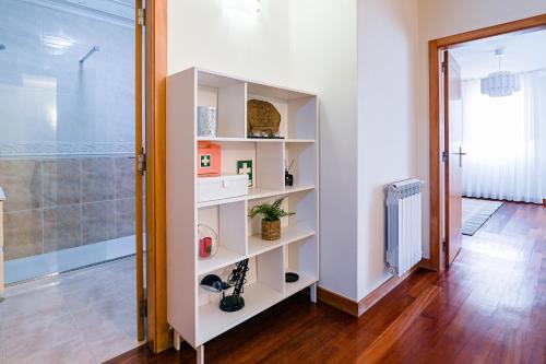 a white book shelf in a room with a shower at Casa Tomé de Sousa in Rates