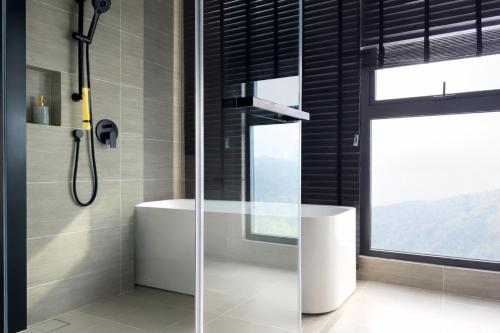 a bathroom with a shower and a sink and a window at Antara Residence By KLIQ in Genting Highlands