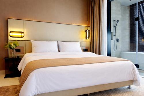 a bedroom with a large bed and a bath tub at Antara Residence By KLIQ in Genting Highlands
