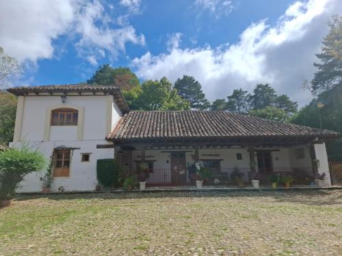 a white house with a brown roof at La Casa Grande in San Cristóbal de Las Casas