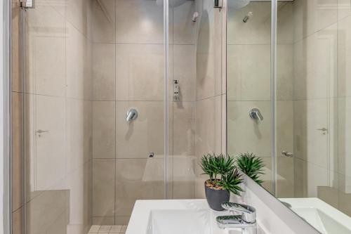 a bathroom with a shower with a sink and a tub at Serene Spaces, Ellipse in Midrand