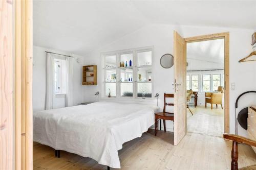 a white bedroom with a large bed and a mirror at 1035-Stege-Teglvaerksvej-39 in Stege