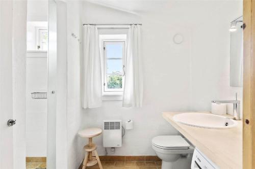 a bathroom with a sink and a toilet and a window at 1035-Stege-Teglvaerksvej-39 in Stege