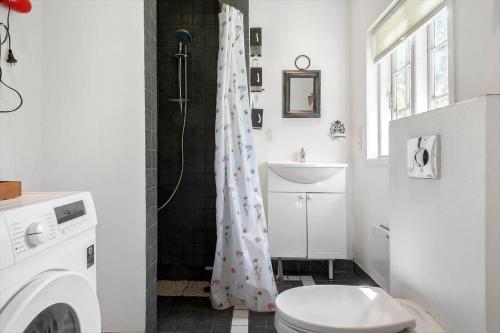 a bathroom with a toilet and a shower curtain at 2002-Stege-Solvgranen-7 in Stege