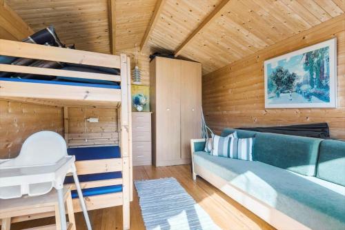 a bedroom with a bunk bed and a couch at R973-Rodvig-Stuven-61 in Rødvig