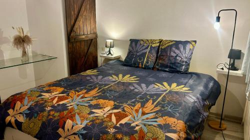 a bedroom with a bed with a colorful blanket at T2 Aix-Les-Bains atmosphere chalet in Aix-les-Bains