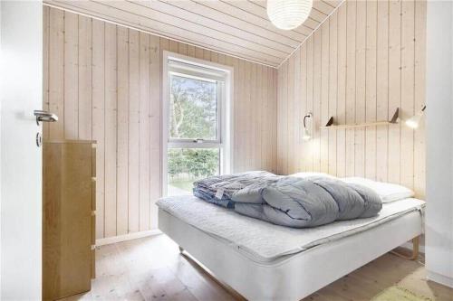 a bedroom with a bed in a room with a window at 8164-Praesto-Klintestien-16 in Præstø