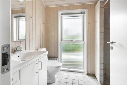 a bathroom with a toilet and a sink and a window at 8164-Praesto-Klintestien-16 in Præstø