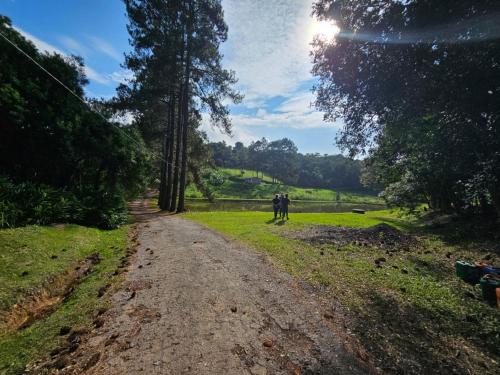 two people walking down a dirt road at Cabana Rota do Vinho in São Roque