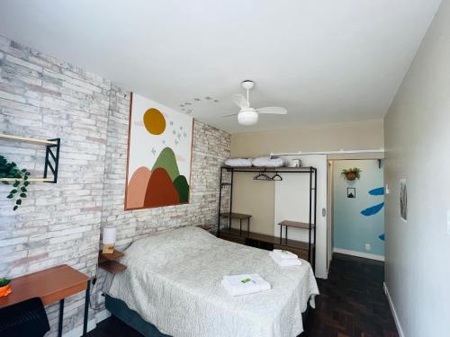 a bedroom with a bed and a brick wall at Apartamento Charme da Glória in Rio de Janeiro
