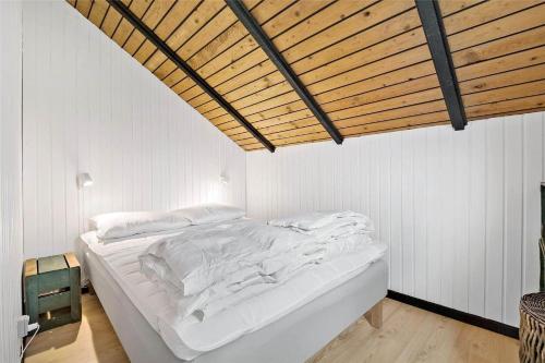 a white bed in a room with a wooden ceiling at 8206-Vordingborg-Havstokken-6 in Vordingborg