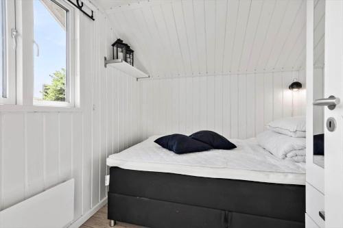 a small bed in a room with a window at S746-Stroby-Ladeplads-Lovsangervej-6 in Strøby Ladeplads