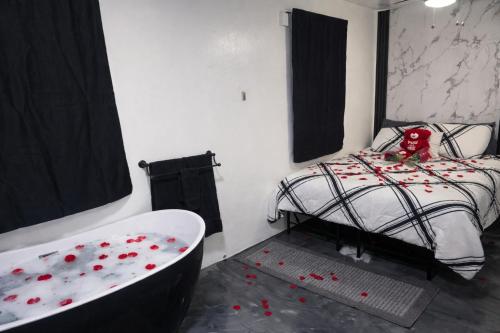 a bedroom with a bed with red rose petals on the floor at RiverHouse Luquillo in Ramos