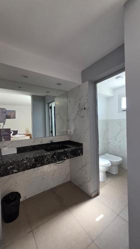 a bathroom with a sink and a toilet and a mirror at Complejo Gran Chacha in Tanti