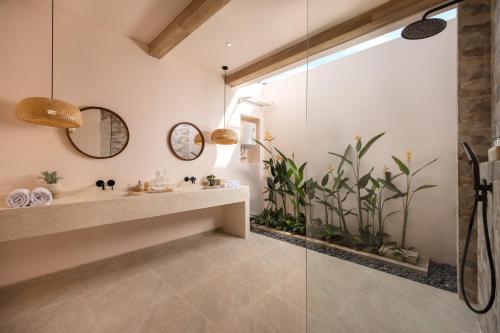 a bathroom with a sink and a glass shower at Bohemian Beachfront Apartments in Pabean Buleleng