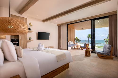 a bedroom with a bed with a view of the ocean at Bohemian Beachfront Apartments in Pabean Buleleng
