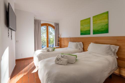 two twin beds in a room with a television at Villa Can Tomeu Capdet in Sant Pere de Ribes