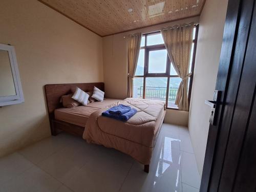 a small bedroom with a bed and a window at Carika Cabin in Diyeng