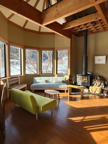 a living room with a couch and a fireplace at 里山でのんびり遊べる宿-風音翆舎 Kanon suisha in Kawaba