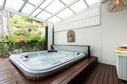 a jacuzzi tub sitting on a wooden deck at The Greenhouse - Spa & Fire - Pet Friendly in Barwon Heads
