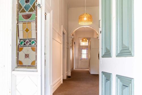 a hallway with a door with a stained glass window at Perfect Point Lonsdale Cottage in Point Lonsdale