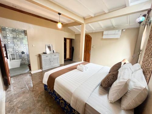 a bedroom with a large bed and a bathroom at The Phalosaa Villa unit Cabana in Ngaglik