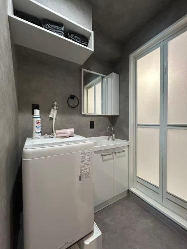 a small kitchen with a refrigerator and a sink at Domo Stay 鳥越 駅近徒歩秋叶原 上野 生活便利 周辺施設充実 in Tokyo